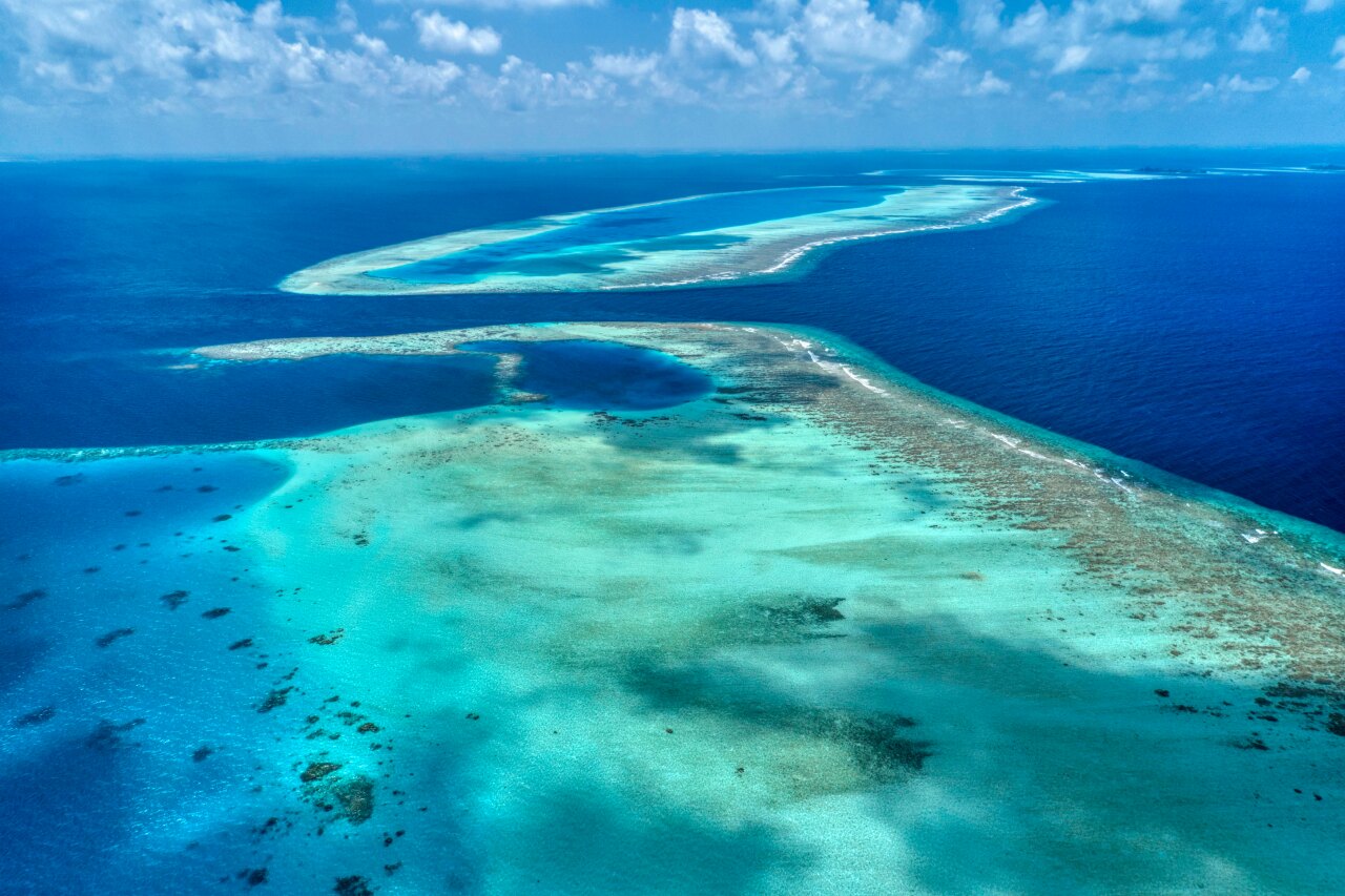 Splendida ripresa aerea con drone che mostra la laguna turchese e le barriere coralline dell'Atollo Vaavu.