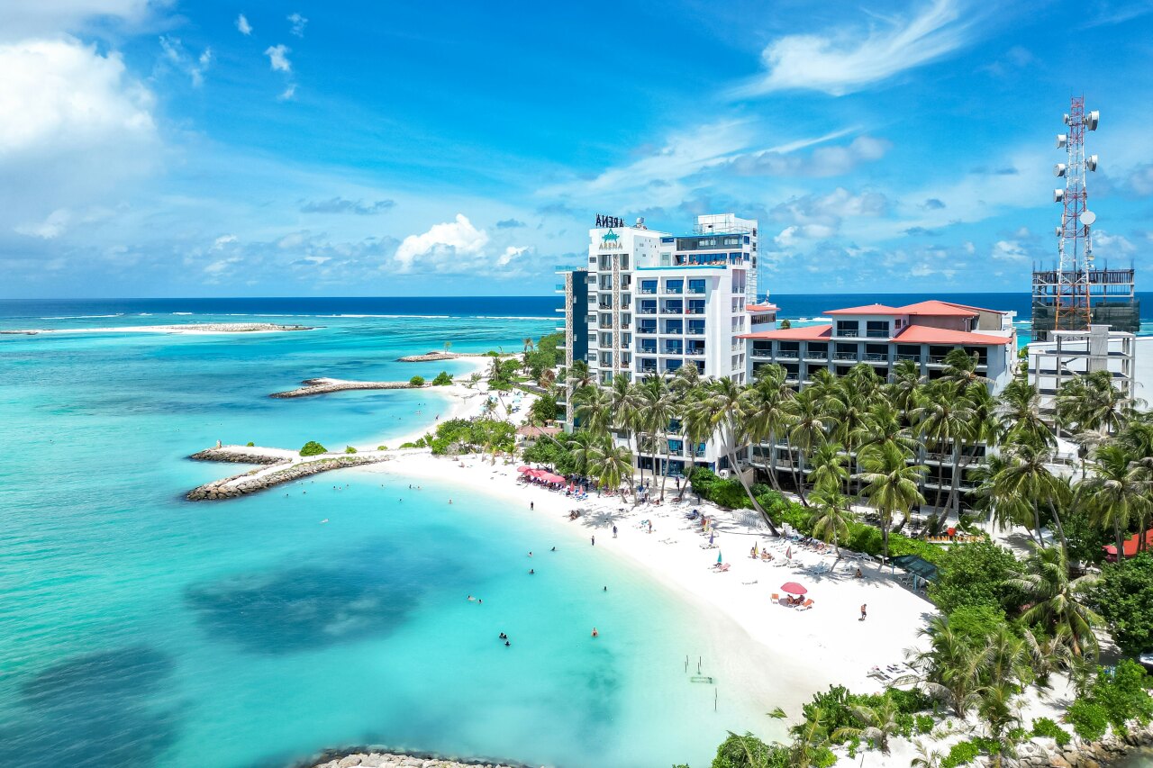 Aerial view of Arena Beach Hotel on Maafushi Island, Kaafu Atoll, featuring white sand beach and clear turquoise water.