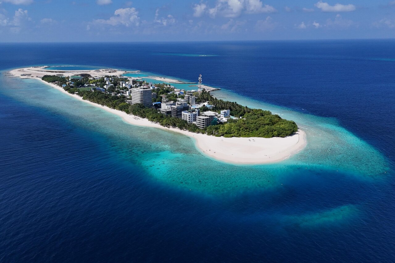 Aerial perspective of Ukulhas local island in Alifu Alifu atoll, showcasing its white sandy beach and turquoise reef