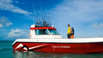 activity, sea - A professional sport fishing boat with Team GT Fishers logo, preparing for big game angling under a clear blue sky.