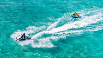 activity, sea - Una moto d'acqua che traina un funtube gonfiabile con due persone dotate di giubbotto salvagente sul mare turchese.
