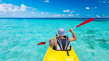 activity, sea, sky - Vista posteriore di una persona che pagaia su un kayak giallo nell'oceano tropicale turchese sotto un cielo azzurro