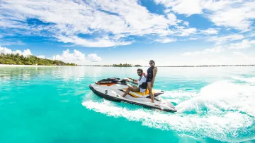 activity, people, sea - A young couple enjoying an exciting jet ski ride across the crystal clear turquoise water on a sunny day in paradise