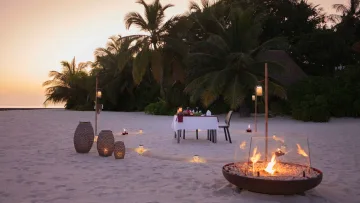 activity, nature, relax, sunset - Un tavolo romantico apparecchiato per due sulla sabbia al tramonto, con braciere e lanterne alle Maldive.