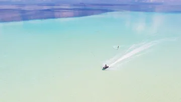 activity, drone-shot, sea - Una ripresa aerea con drone di una persona che fa wakeboard trainata da una moto d'acqua nella laguna turchese.