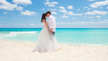 activity, beach, people - A loving couple sharing an intimate moment during a romantic wedding ceremony on a white sandy beach in the tropics.