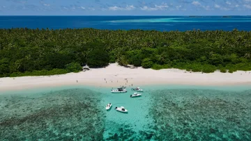 activity, drone-shot, nature, reef, sea - Veduta aerea di un'isola tropicale con spiaggia di sabbia bianca, motoscafi su acqua turchese e vegetazione lussureggiante.
