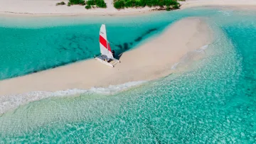 activity, drone-shot, sea - Aerial view of a red and white catamaran anchored on a pristine white sandbank surrounded by turquoise ocean waters.