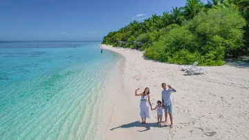beach, people - Happy family with a child waving on a beautiful white sand tropical beach with crystal clear turquoise water.