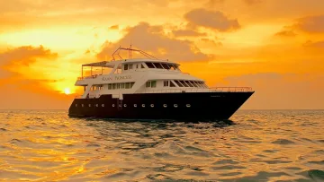 luxury, sea, sunset - Una barca da crociera di lusso chiamata Kaani Princess naviga sull'oceano durante un vibrante tramonto tropicale
