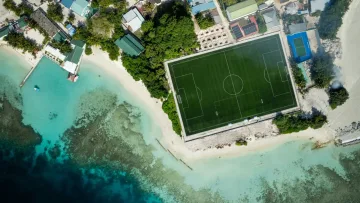 drone-shot, local-island, nature, sea - Veduta aerea del campo da calcio verde accanto all'oceano turchese sull'isola locale di Bodufolhudhoo, Maldive.