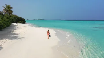 beach, local-island, people, snorkeling - Aerial view of a woman in a red bikini walking on the white sandy beach of Dhigurah island with turquoise water