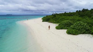 beach, local-island, people - Aerial view of a woman walking on the white sandy bikini beach of Feridhoo local island in Alifu Alifu Atoll.