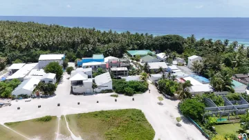 drone-shot, local-island - Aerial drone perspective of the local island Fulhadhoo in Baa Atoll, showing village infrastructure and lush forest