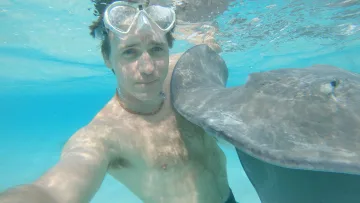 activity, animal, local-island, snorkeling, underwater - A man wearing a snorkeling mask taking a selfie underwater with a friendly stingray at Fulidhoo Island in Vaavu Atoll.