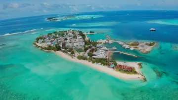 drone-shot, local-island, nature, sea - Wide angle drone shot capturing Gulhi Island in Kaafu Atoll, with its turquoise lagoon, boat harbor and beach.