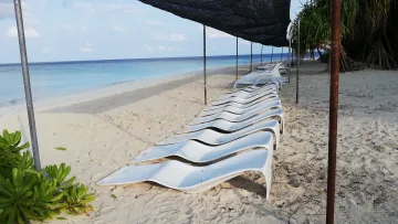 beach, bikini-beach, facilities, local-island - Lettini bianchi allineati all'ombra sulla spiaggia dell'isola locale di Hangnaameedhoo, atollo di Alifu Dhaalu.