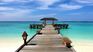 local-island - A scenic wooden jetty stretching into the turquoise lagoon of Hanimaadhoo Island in the Haa Dhaalu Atoll, Maldives.