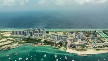 drone-shot, local-island - A wide aerial view of the local island Hulhumalé in the Kaafu Atoll, showcasing modern buildings, harbors, and boats.