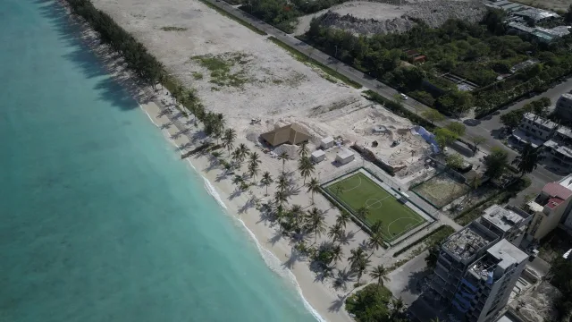 beach, drone-shot, local-island - Drone view of the turquoise sea and sandy beach coastline of Hulhumale island in Kaafu Atoll, with a football field.