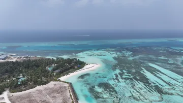 drone-shot, local-island, reef, sea - Vista aerea da drone dell'isola locale di Huraa nell'atollo di Kaafu, con palme, spiaggia bianca e reef turchese