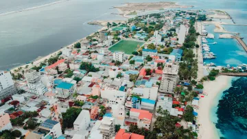 Stunning aerial drone view of the local island Maafushi in the Kaafu Atoll, featuring the harbor and cityscape.