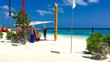 activity, beach, local-island, sea - Watersports activity station on Maafushi local island, Kaafu Atoll, featuring inflatable gear and beach flags.