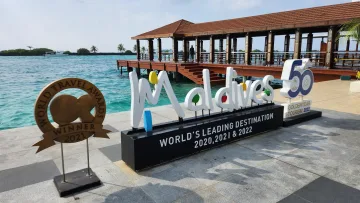 local-island - Il cartello del premio World Leading Destination 2020-2022 a Male, atollo di Kaafu, con pontile e mare turchese.