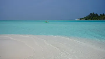 bikini-beach, local-island, sea - Una coppia in kayak sulle acque turchesi cristalline dell'isola locale di Mathiveri nell'atollo di Alifu Alifu.