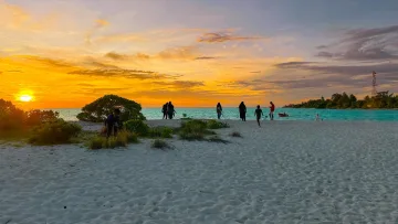 beach, local-island, people, sunset - Sagome di persone sulla spiaggia di sabbia bianca dell'isola di Mathiveri, atollo di Alifu Alifu, durante un tramonto.