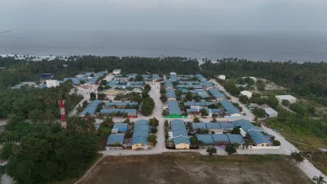 drone-shot, local-island - Prospettiva aerea dell'isola locale di Nolhivaranfaru nell'atollo di Haa Dhaalu, Maldive, con case e vegetazione.