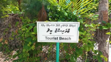 beach, bikini-beach, culture, local-island - White sign with the inscription Tourist Beach in English and Dhivehi language on Omadhoo island, Alifu Dhaalu Atoll