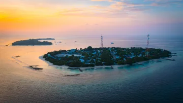 drone-shot, local-island, sunset - Aerial sunset drone shot of Rasdhoo local island in North Ari Atoll, featuring lush vegetation and communications towers.