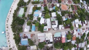 drone-shot, local-island - Top-down drone view of the local island of Rasdhoo in North Ari Atoll showing houses, trees and sandy coastline.