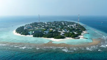 drone-shot, local-island - Stunning aerial drone shot of the local island of Rasdhoo in the North Ari Atoll, showcasing its green landscape, white beaches, and surrounding coral reef.