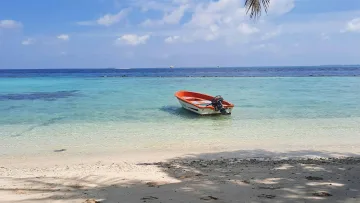 local-island, nature, sea - Una barca a motore arancione ancorata nella laguna turchese dell'isola di Thulusdhoo nell'atollo di Kaafu.