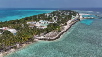 drone-shot, local-island, nature - Drone perspective of Vashafaru local island, Haa Alifu Atoll, with turquoise lagoon, tropical palm trees, and village.