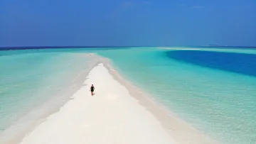 beach, drone-shot, sea - Aerial view of a person walking on the white sand of Madivaru Finolhu sandbank surrounded by turquoise ocean waters.