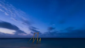 nature, sea, sky - A calm dark blue ocean under a vast clear night sky filled with stars, featuring a rustic wooden jetty in water.