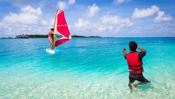 activity, people, sea, sky - Un istruttore di windsurf guida un allievo nelle acque turchesi e cristalline di una splendida laguna tropicale.